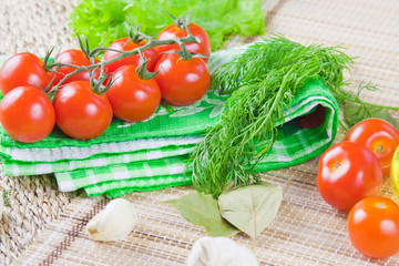 red ripe tomatoes with fresh greenery on a napkin
