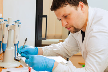 Researcher writing data into lab journal