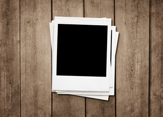 Stack of old instant photos at grunge wooden background