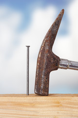 Hammer and nail with wooden board