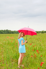 frau mit regenschirm im Mohnfeld