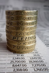Stos monet jednofuntowych na tle notowań giełdy © photoemission