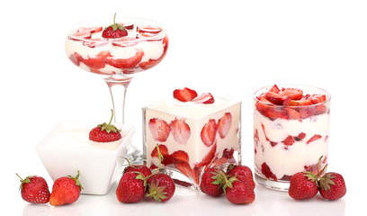 Glasses of ripe strawberries with cream isolated on white