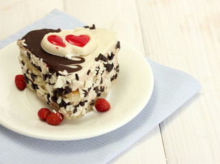 sweet cake with chocolate on plate on wooden table