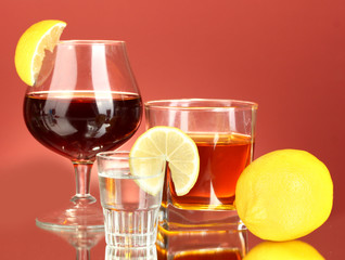 a variety of alcoholic drinks on red background