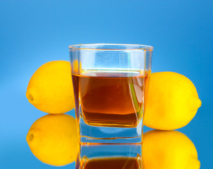 glass of whiskey on blue background close-up