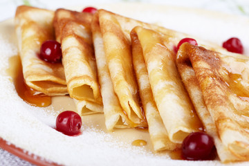 Pancakes with cranberry berries and honey on a plate