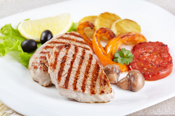 Grilled steak with vegetables on white plate