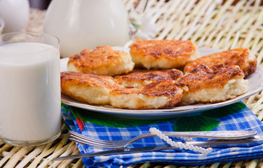 fried curd pancakes on a dish and milk