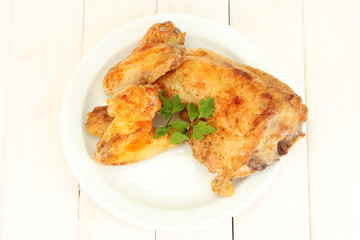 roasted chicken wings and leg with parsley in the plate
