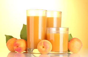 glasses of apricot juice on yellow background