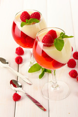 fruit jelly with raspberries in glasses on wooden table