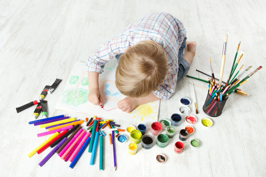 Child drawing picture with crayon  in album using a lot of paint
