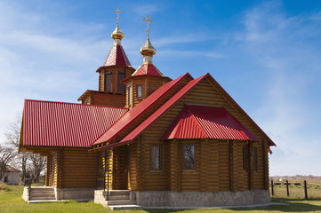 Fototapeta na wymiar The new wooden orthodox church with golden dome.