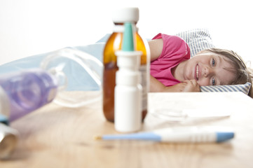 Obraz na płótnie Canvas chora dziewczynka w jej łóżku i narkotyków, inhalator i termometr.