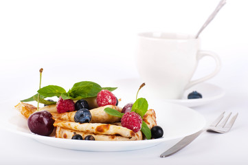 Pancakes with berries and mint and cup of coffee