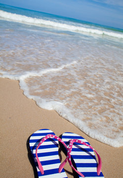 Colorful flip-flop sandals on sea beach