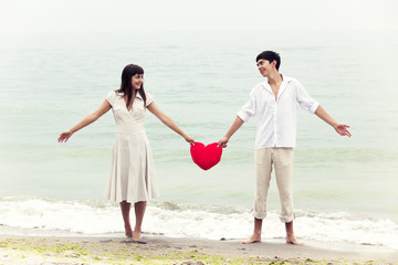 Closeup portrait of happy couple at the beach with heart.