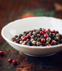 Different types of peppercorns in a small bowl