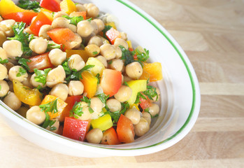Chick pea salad in a bowl sitting on a wooden table.