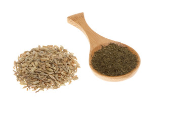 Dill seeds and dried dill on a wooden spoon