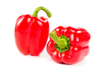 two fresh red peppers on white
