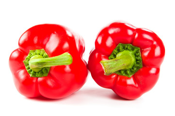 two fresh red peppers on white