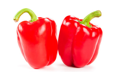 two fresh red peppers on white