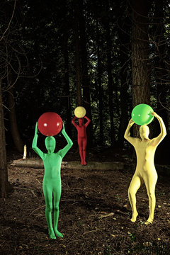 strange forest people playing with colorful balls