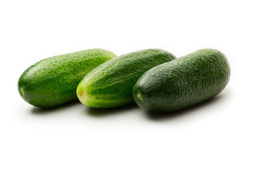 Fresh green cucumbers on white