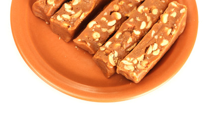 Cut sherbet with nuts in the plate on white background close-up