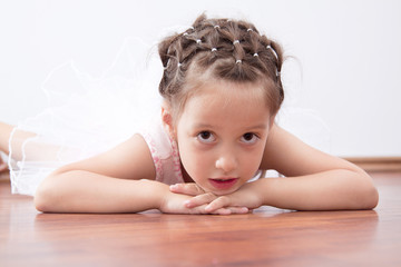 Beautiful little ballerina laying on the floor
