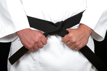 karate man tying the knot to his black belt © dekanaryas