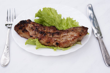 Appetizing juicy fried meat with green salad