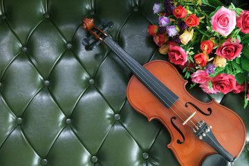 violin and bouquet flower on green leather background