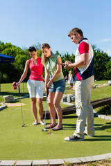 Leute spielen Minigolf im Sommer