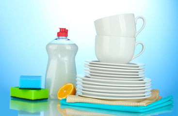 empty clean plates and cups with dishwashing liquid, sponges