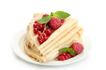 Delicious pancakes with berries and jam on plate on wooden