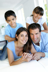 Fototapeta premium Portrait of happy family laying down bed