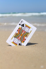 The king card in the sand, beach background