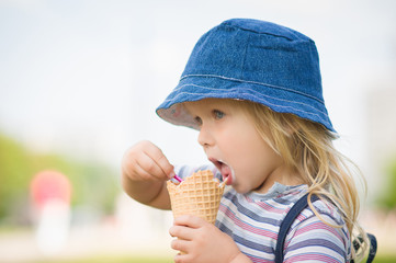 Adorable girl in blue hat eat ice cream