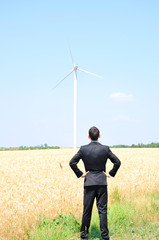 Business man near wind farm
