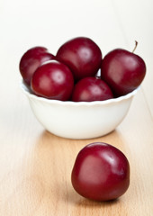Ripe plums in a white bowl