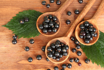 Fresh black in wooden spoons on wooden background close-up