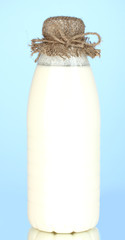 bottle of milk on blue background close-up