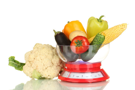 Ripe Fresh Vegetables In The Kitchen Scales Isolated On White