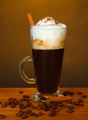 glass of coffee cocktail with coffee beans on brown background