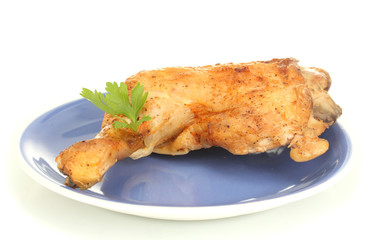 roasted chicken leg with parsley in the plate isolated on white