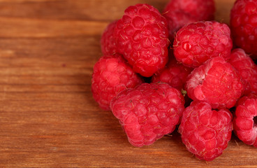 Fresh raspberries on wooden background close-up