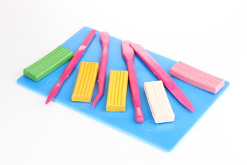 Children bright plasticine on desk with stacks isolated on